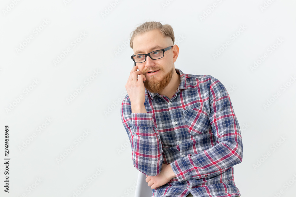 Bearded handsome man talking on the phone over white background
