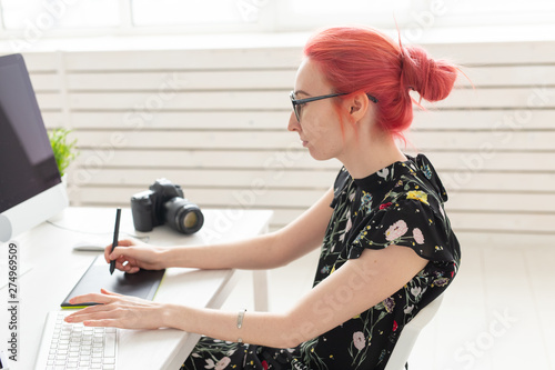 Illustrator, graphic designer, animator and artist concept - creator woman with beautiful red hair and glasses drawing in laptop