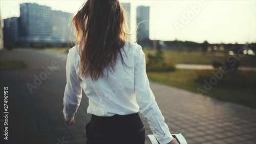 Close up, slow motion. Business girl with a passport and tickets goes to the departure area. Dressed in a white shirt and sun glasses. Style casual. Business trip by business class plane or