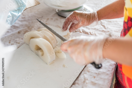 woman's hands slicing slices of cuttlefish