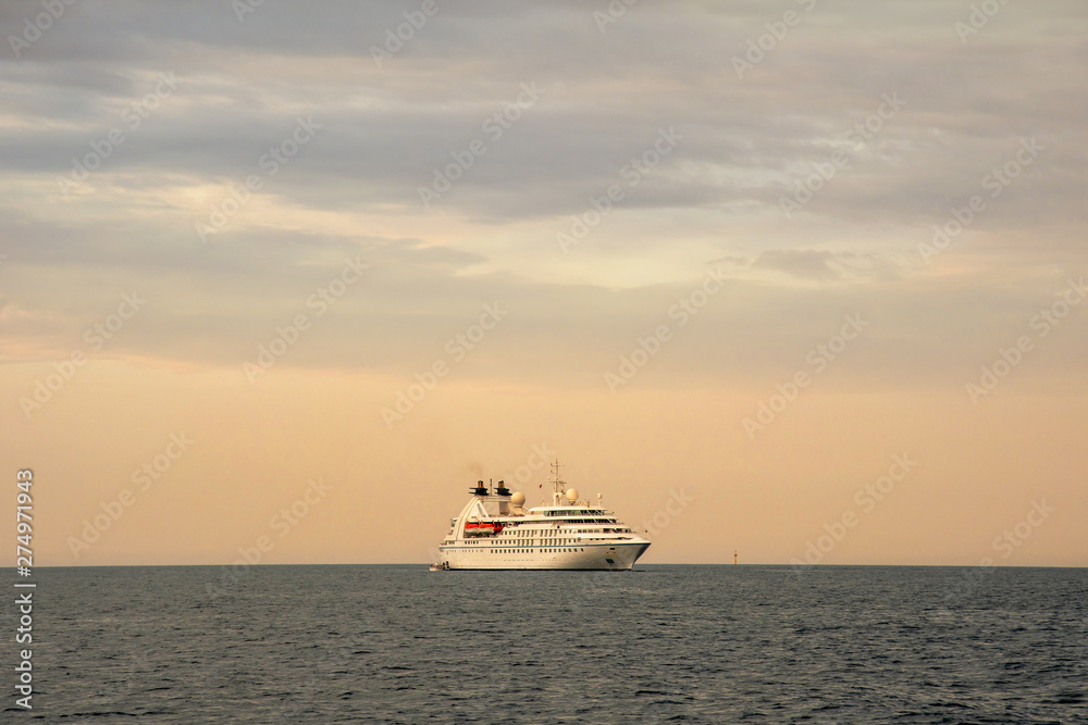 Seascape with a cruise ship on the horizon  and cloudy sunset sky, Portofino, Genoa, Liguria, Italy