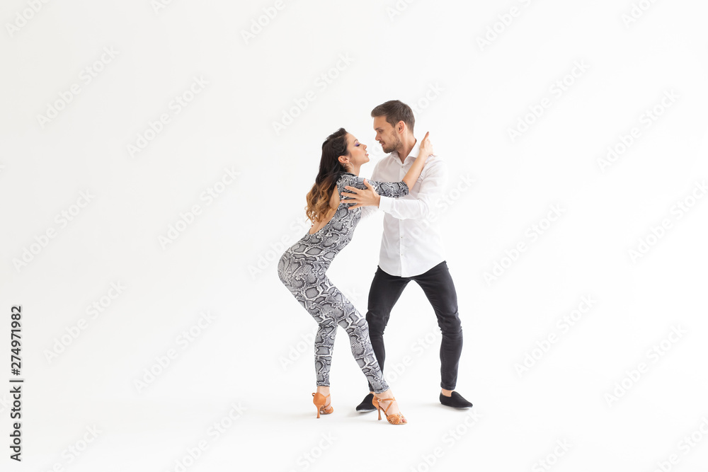 Social dance, bachata, kizomba, tango, salsa, people concept - Young couple dancing over white background with copy space