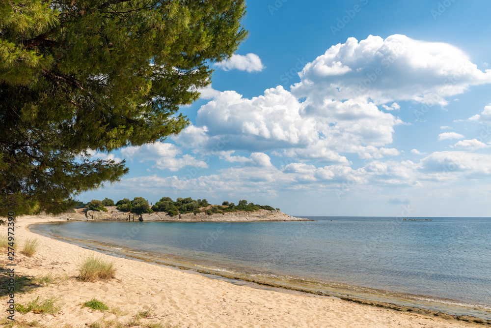 Landscape with beach, the sea and the clouds in the blue sky