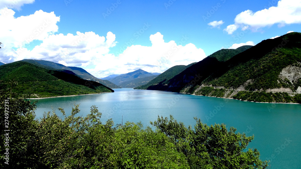 Beautiful view of the lake, nice color, surrounded by mountains. Background