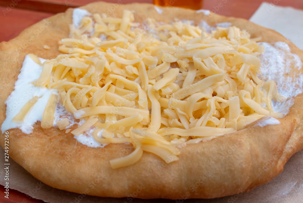 Hungarian langos: fried dough topped with cheese, sour cream, garlic, and onions.