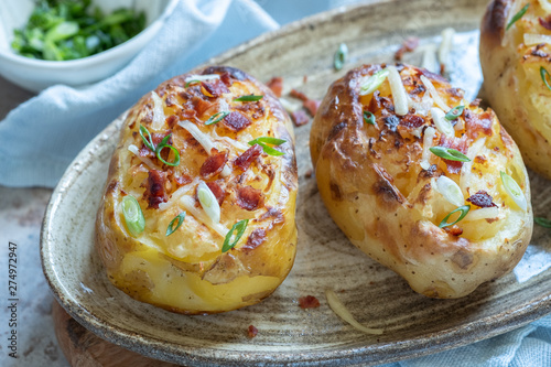 Baked loaded potato with bacon, cheese, sour cream and onion