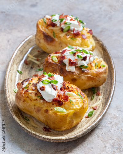 Baked loaded potato with bacon, cheese, sour cream and onion