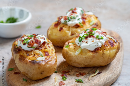 Baked loaded potato with bacon, cheese, sour cream and onion