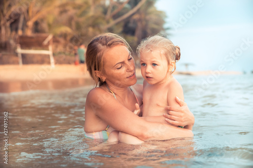 Family vacation child mother beach swimming together in sea authentic family vacation lifestyle © splendens