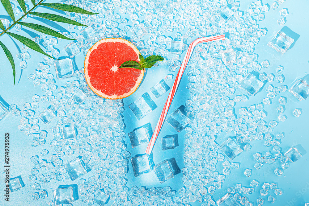 cold drink. ice on a light blue background laid out in the form of a glass with a tubule for a cocktail and a slice of grapefruit. The concept of a cold summer drink in the heat to quench your thirst. - obrazy, fototapety, plakaty 