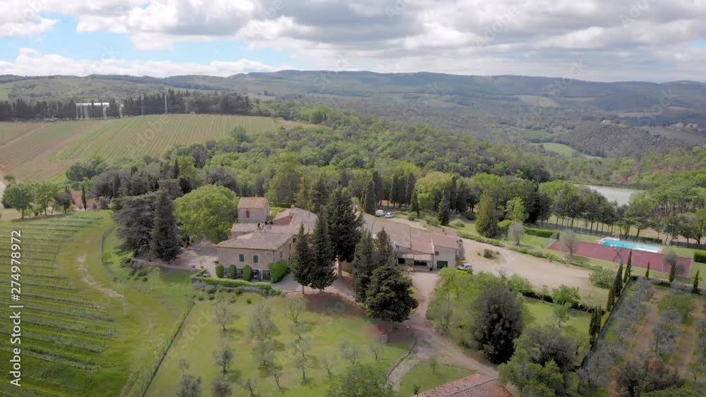 aerial view of small farm or hotel between picturesque meadows in Tuscany region in sunny summer day aerial view of small farm or hotel between picturesque meadows in Tuscany region in sunny summer day