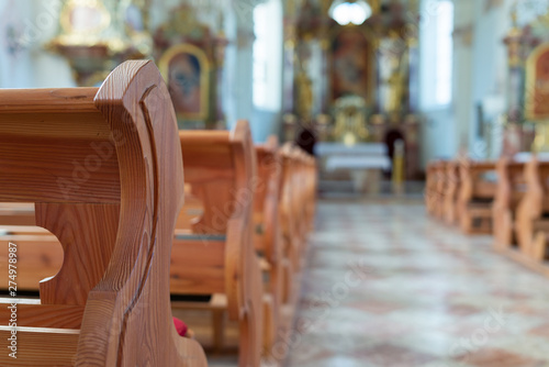 Leere Holzbänke in einer katholischen Kirche