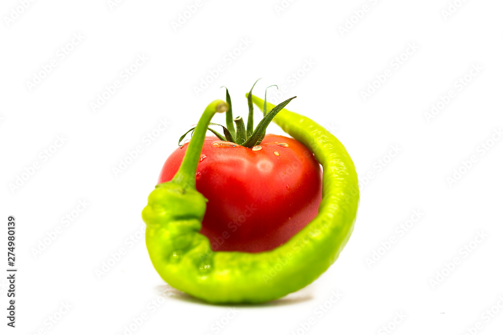 ripe fresh organic tomato in drops of dew and green hot chili pepper isolated on white background	