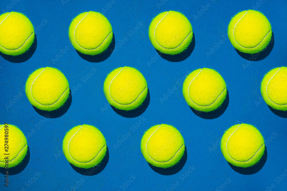 Creative composition made with tennis ball on blue background. Sport tennis pattern. Flat lay.
