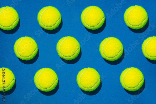 Creative composition made with tennis ball on blue background. Sport tennis pattern. Flat lay.