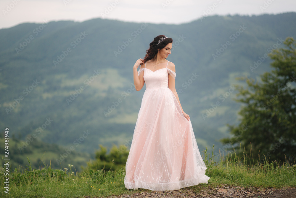 Charming bride in beautiful Carpathian mountais. Elegant woman in beautiful dress Charming bride in beautiful Carpathian mountais. Elegant woman in beautiful dress
