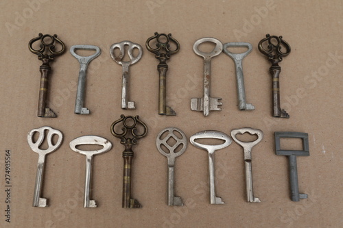 Mettalic vintage keys on the brown background, figures from keys