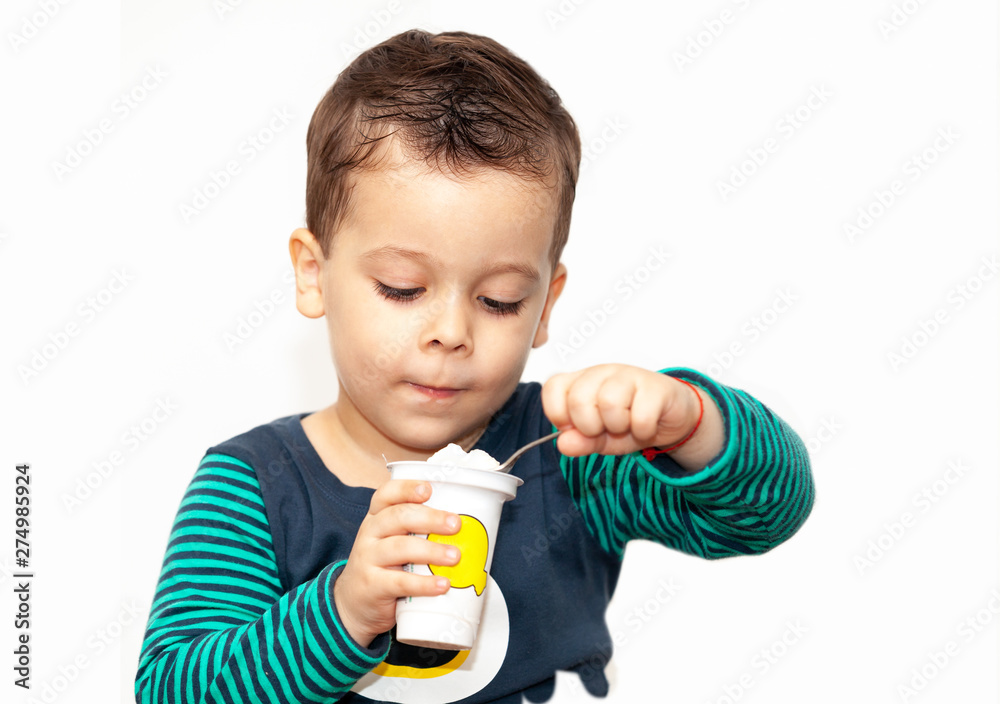 little kid eating yogurt on white background little kid eating yogurt on white background