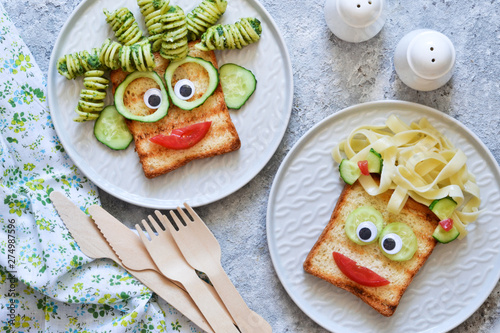 Funny faces - lunch for the child. Sandwich with vegetables. View from above.