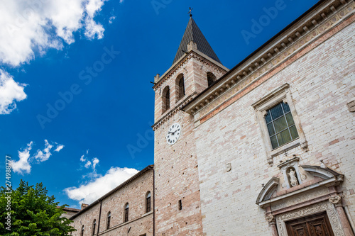 The church of Santa Maria Maggiore, the portal adorned with Romanesque friezes and the Romanesque bell tower with the clock. In Spello, province of Perugia, Umbria, Italy.