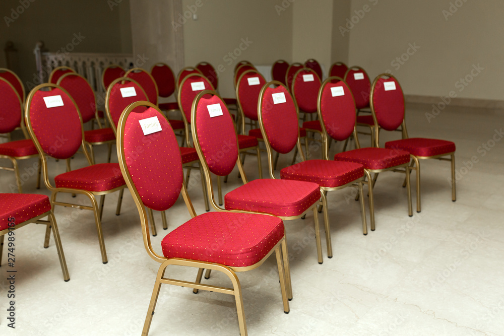 Wedding ceremony in the banquet hall indoors. Rows of chairs for guests ...