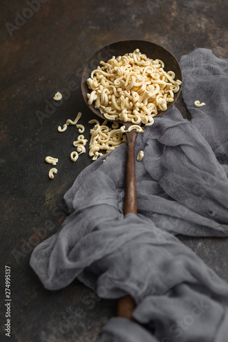 Homemade Small Macaroni in Old Ladel on Black Background