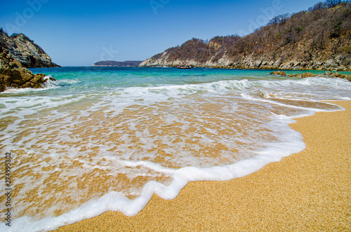 Paradise sand beach with turquoise blue water in Huatulco, Oaxaca, Mexico photo