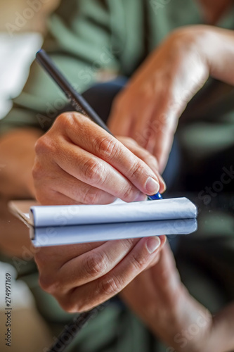 Woman hand writing anything on a paper
