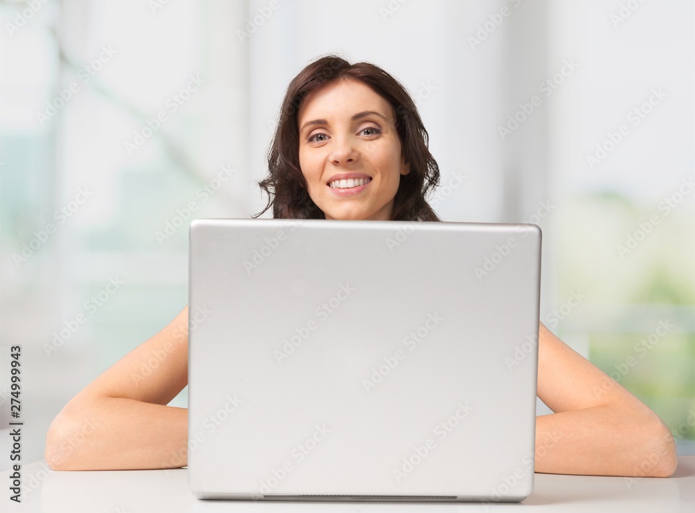 Attractive young woman speaking phone and using laptop Attractive young woman speaking phone and using laptop