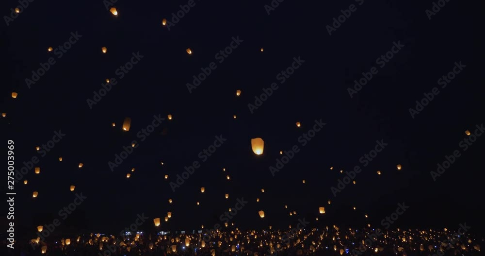 People floating light lanterns at night