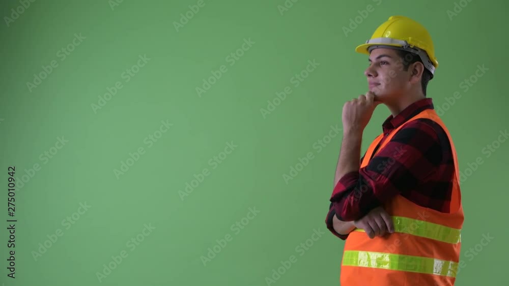 Profile view of happy young multi ethnic man construction worker thinking