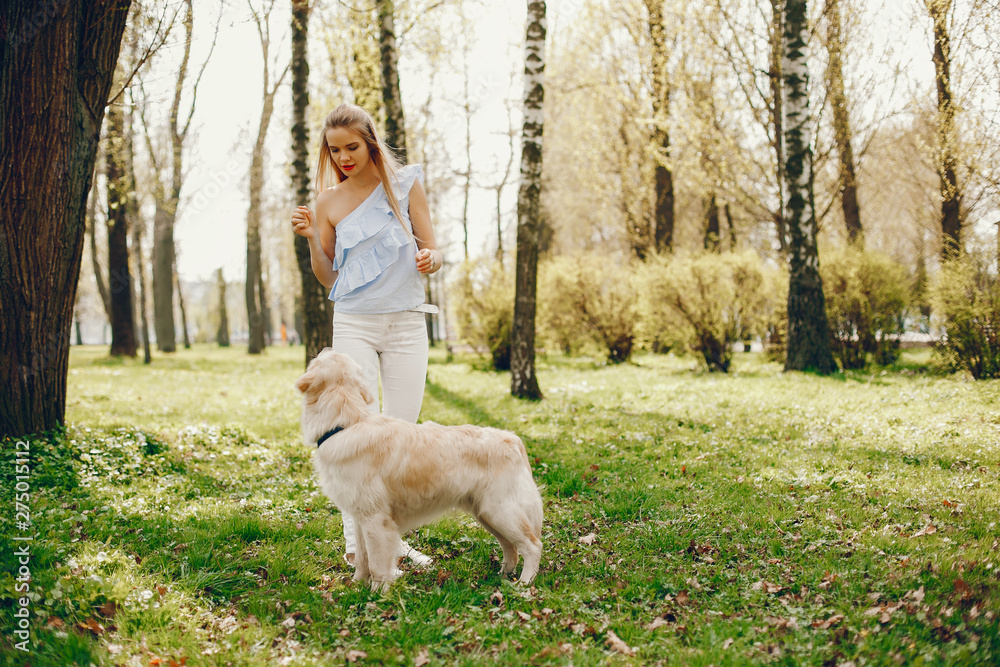 Beautiful and young elegant girl playing with her dog in a sunny summer park Beautiful and young elegant girl playing with her dog in a sunny summer park