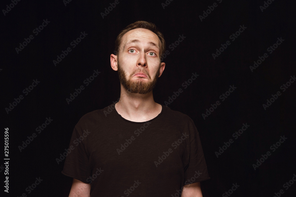 Close up portrait of young man isolated on black studio background. Photoshot of real emotions of male model. Wondering, exciting and astonished. Facial expression, human emotions concept. Close up portrait of young man isolated on black studio background. Photoshot of real emotions of male model. Wondering, exciting and astonished. Facial expression, human emotions concept.