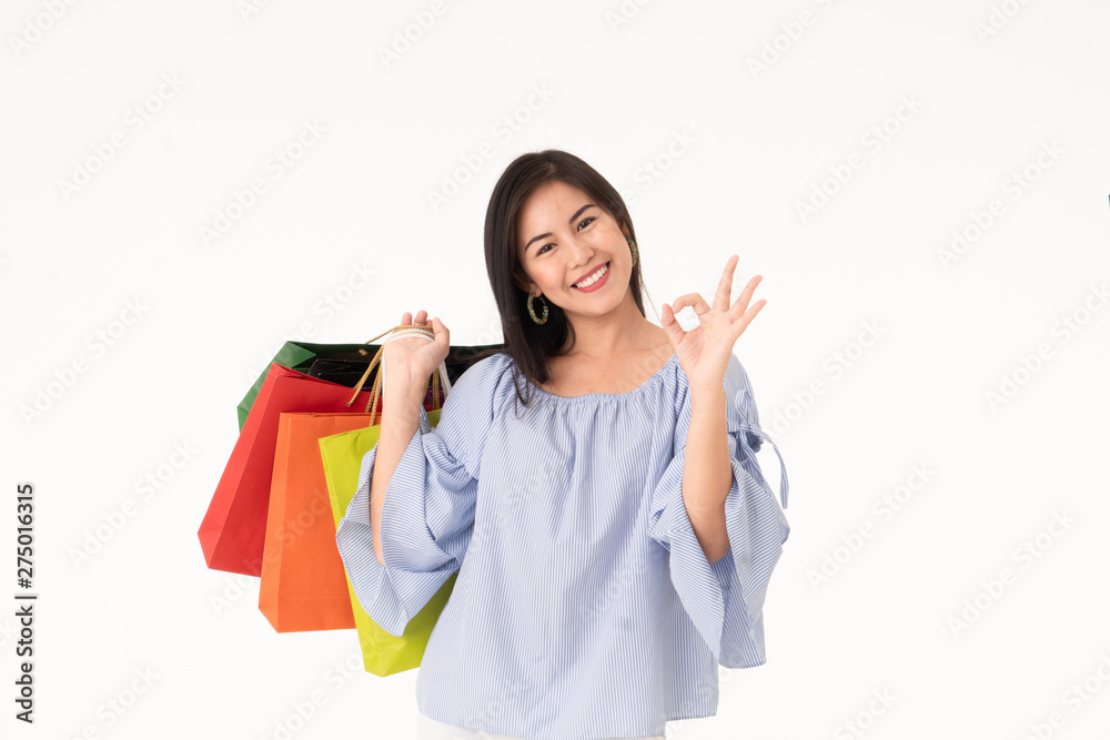 Happy Asian young woman carrying shopping bags isolated on white background Happy Asian young woman carrying shopping bags isolated on white background