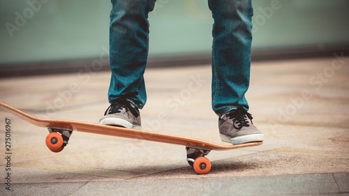 Skateboarder legs riding skateboard on city street