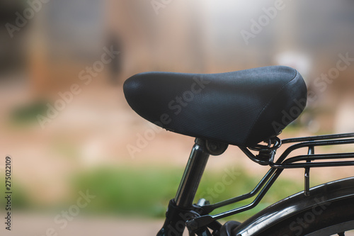 Black bicycle cushion that is parked on the side of the house