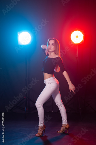 Dance and people concept - young sexy woman dancing in the dark and enjoying it