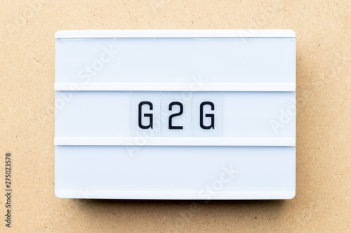 White lightbox with word G2G (abbreviation of Government to government) on wood background