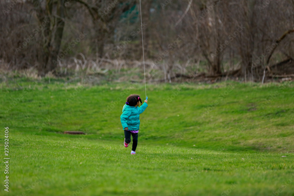 little girl running in park flying kite little girl running in park flying kite