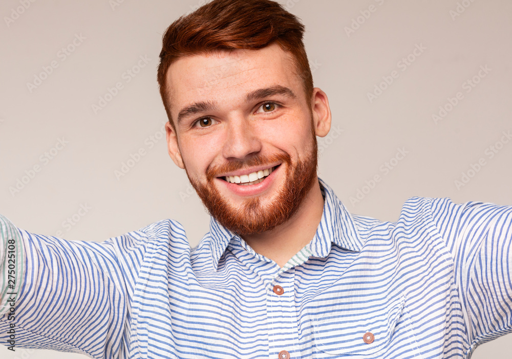 Handsome millennial guy making selfie and smiling