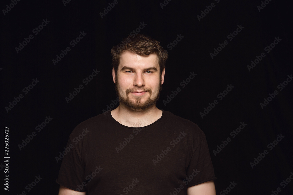 Close up portrait of young man isolated on black studio background. Photoshot of real emotions of male model. Smiling, feeling happy. Facial expression, pure and clear human emotions concept. Close up portrait of young man isolated on black studio background. Photoshot of real emotions of male model. Smiling, feeling happy. Facial expression, pure and clear human emotions concept.