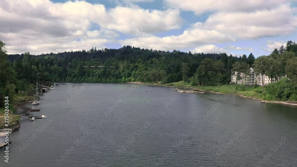aerial dolly forward down river showing forest and docks. aerial dolly forward down river showing forest and docks.