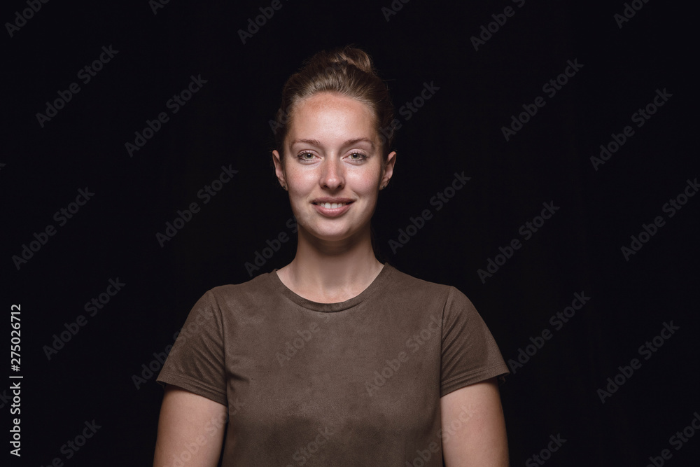 Close up portrait of young woman isolated on black studio background. Photoshot of real emotions of female model. Smiling, feeling happy. Facial expression, pure and clear human emotions concept. Close up portrait of young woman isolated on black studio background. Photoshot of real emotions of female model. Smiling, feeling happy. Facial expression, pure and clear human emotions concept.