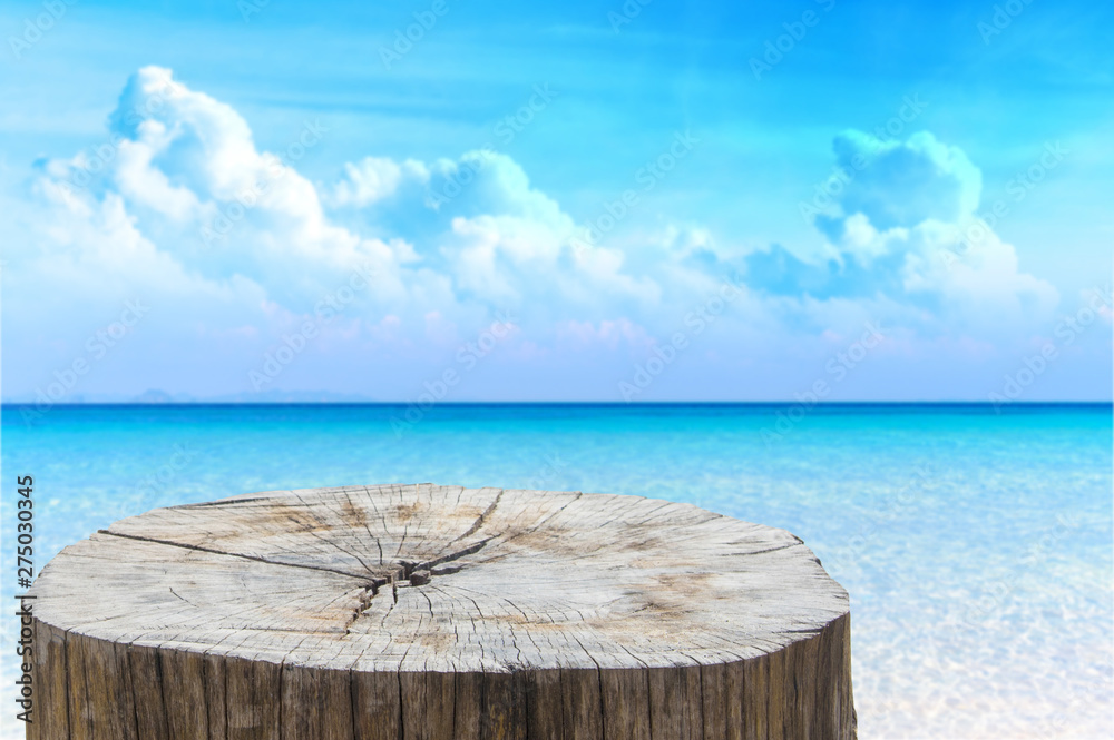 Wooden desk or stump on sand beach in summer. background. For