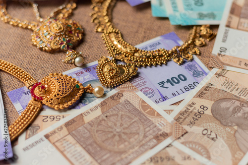 Concept of black money, IT raid, confiscated or unaccounted Money showing Indian currency notes with jewelry photo