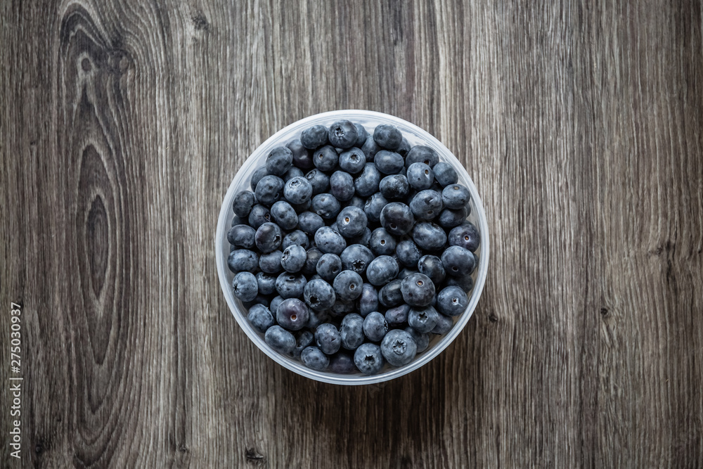 Ripe tasty blueberries and berries on a wooden table in a bowl Ripe tasty blueberries and berries on a wooden table in a bowl