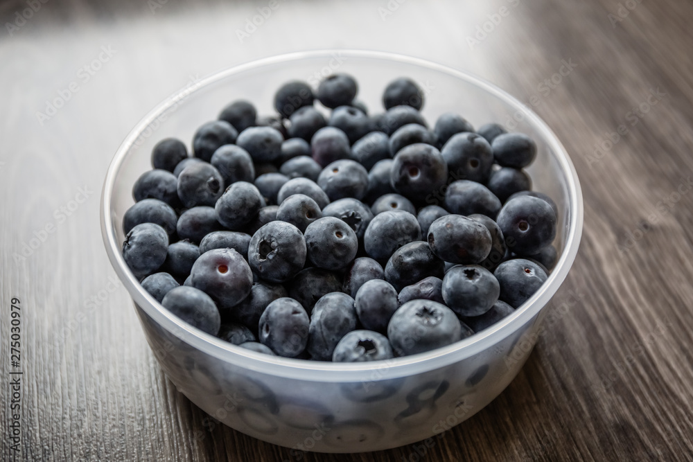 Ripe tasty blueberries and berries on a wooden table in a bowl Ripe tasty blueberries and berries on a wooden table in a bowl