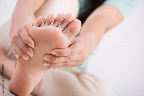 Healthcare and medical concept. Woman massaging her painful foot.