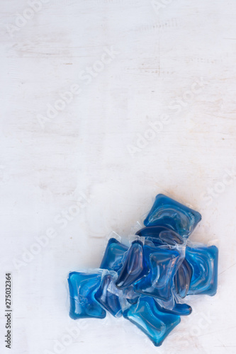 Set of blue Washing detergent capsule isolated on white wooden background. Close-up.Liquid soap.