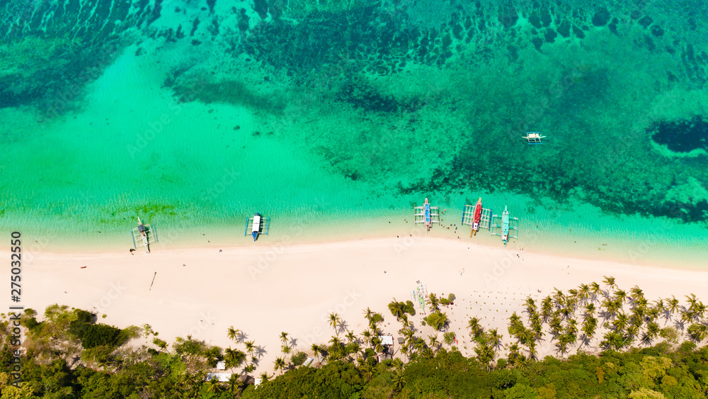 Turquoise lagoon with a coral reef and white beach. Beach with white sand and palm trees, view from above. Puka Shell Beach, Boracay Island, Philippines, aerial view. Turquoise lagoon with a coral reef and white beach. Beach with white sand and palm trees, view from above. Puka Shell Beach, Boracay Island, Philippines, aerial view.